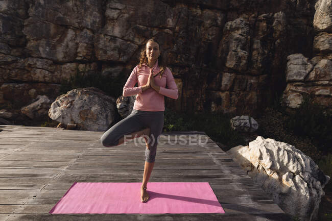 Ruhige kaukasische Frau, die Yoga auf einem Bein stehend in ländlicher Berglandschaft praktiziert. gesundes Leben, netzfrei und naturnah. — Stockfoto