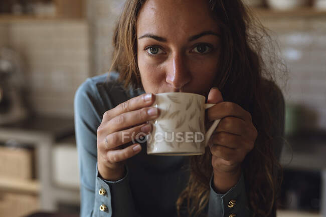 Портрет жінки з котеджу на кухні, що стоїть на прилавках для пиття кави. Просте життя у сільській місцевості.. — стокове фото