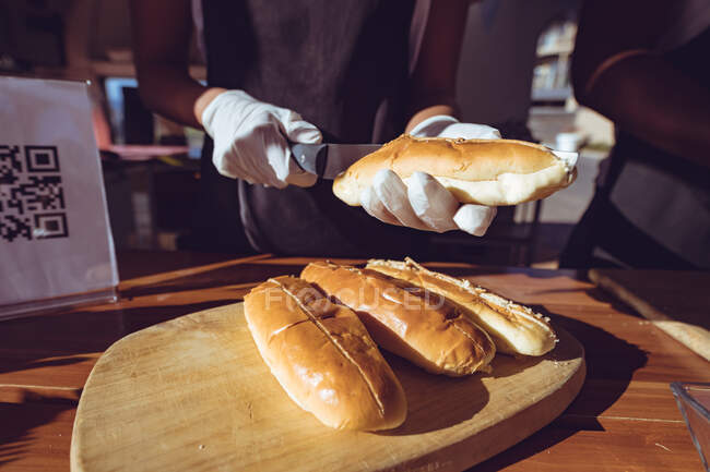 Midsection de femme préparant des hot-dogs derrière le comptoir dans un camion de nourriture. entreprise indépendante et concept de service de restauration de rue. — Photo de stock