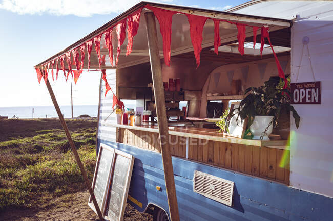 Vista general del camión de comida junto al mar en un día soleado. concepto de empresa independiente y servicio de comida callejera. - foto de stock