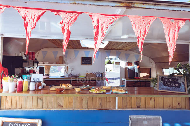 General view of food truck with ready food and red bunting. independent business and street food service concept. — Stock Photo