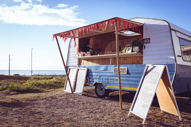 General view of food truck by seaside on sunny day. independent business and street food service concept. — Stock Photo
