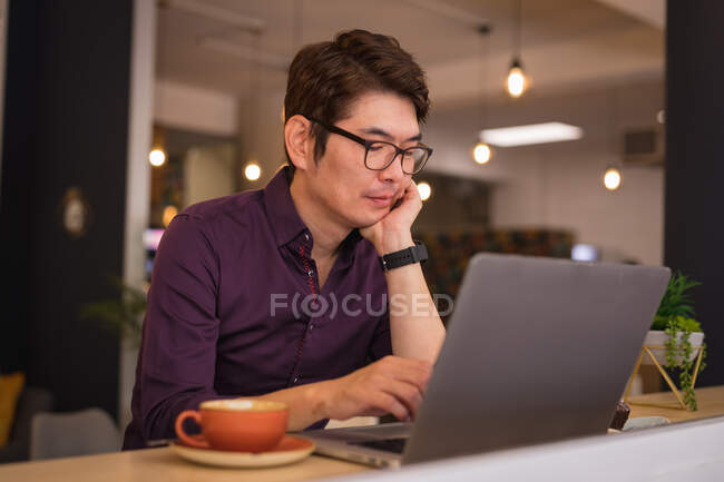 Homem de negócios asiático usando laptop no lobby do hotel. viagens de negócios, nômade digital em movimento e sobre no conceito de cidade. — Fotografia de Stock