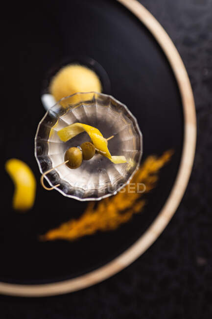 Vista frontal del cóctel de ginebra con aceitunas frescas en bandeja de madera. concepto de bebida de cóctel tropical y de verano - foto de stock