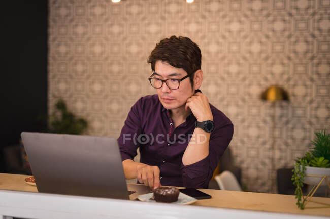 Asian businessman using laptop in hotel lobby. business travel, digital nomad on the go out and about in city concept. — Stock Photo