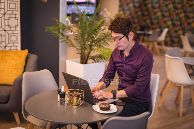 Empresário asiático usando laptop no café ou lobby do hotel. viagens de negócios, nômade digital em movimento e sobre no conceito de cidade. — Fotografia de Stock