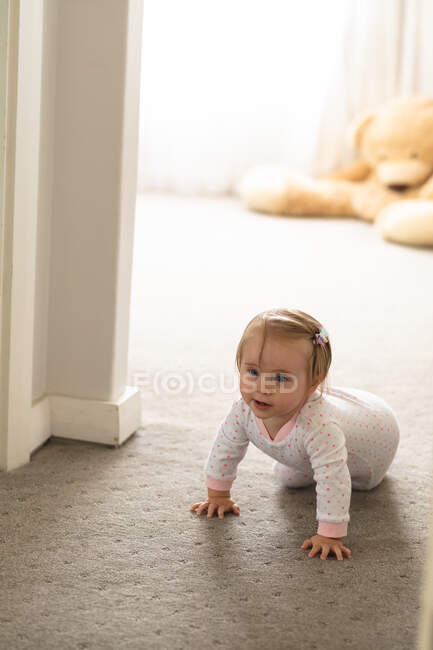Caucasian cute baby crawling on the floor at home. motherhood, love and baby care concept — Stock Photo