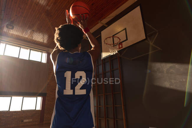 Mixed race male basketball player practicing shooting with ball. basketball, sports training at an indoor court. — Stock Photo