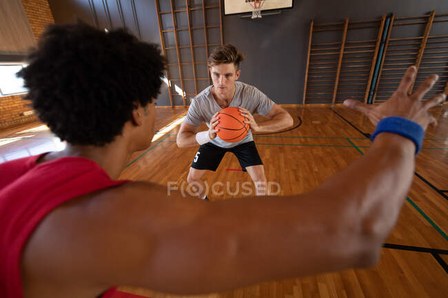 Two diverse male basketball players practice dribbling ball. basketball, sports training at an indoor court. — Stock Photo