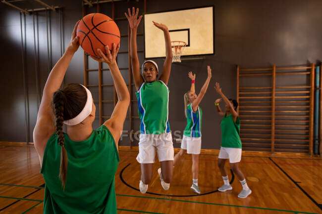 Diverse female basketball team practicing shooting with ball. basketball, sports training at an indoor court. — Stock Photo