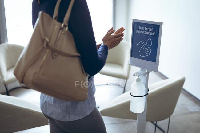 Бізнес-леді дезінфікує руки. робота в сучасному офісі під час пандемії коронавірусу 19 . — стокове фото