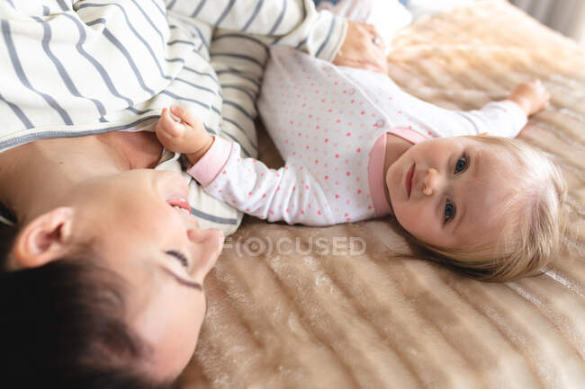 Кавказька мати з немовлям лежали разом у ліжку. материнство, любов і догляд дітей — стокове фото