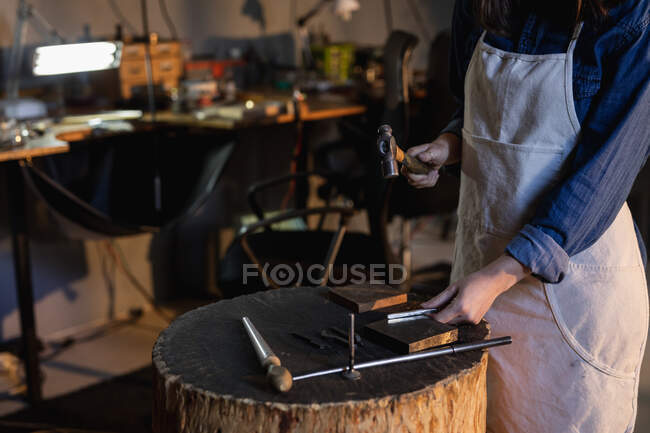 Mittelteil einer Juwelierin, die Schmuckwerkzeuge hält und in der Werkstatt Schmuck herstellt. Selbstständiger Handwerksbetrieb. — Stockfoto