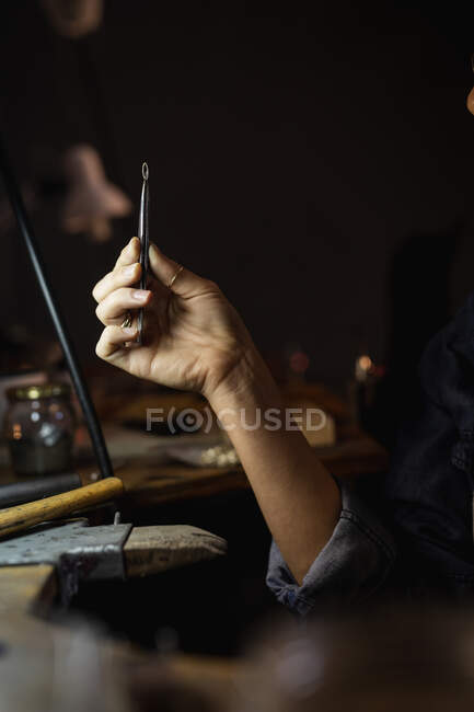 Nahaufnahme einer Juwelierin, die Juwelierwerkzeuge in der Hand hält und Schmuck herstellt. Selbstständiger Handwerksbetrieb. — Stockfoto