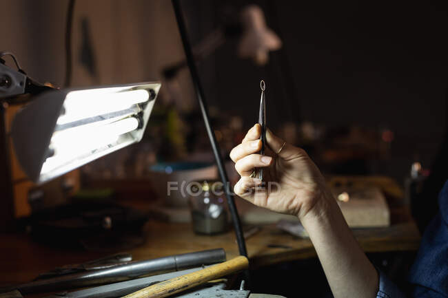 Nahaufnahme einer Juwelierin, die Juwelierwerkzeuge in der Hand hält und Schmuck herstellt. Selbstständiger Handwerksbetrieb. — Stockfoto