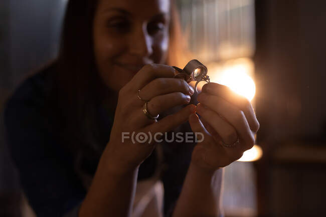 Mulher branca joalheiro em oficina usando lupa para inspecionar o anel. proprietário do negócio artesanal independente do ofício. — Fotografia de Stock