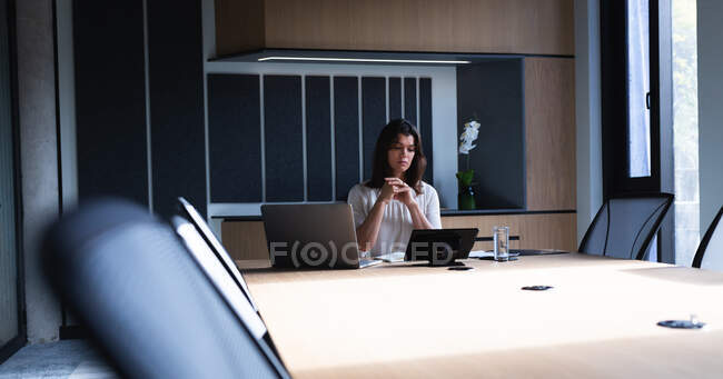 Donna d'affari caucasica che utilizza il computer portatile mentre è seduto in sala riunioni presso l'ufficio moderno. concetto di business e ufficio — Foto stock