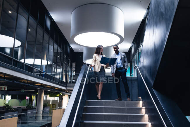 Diverso empresário e empresária discutindo juntos de pé nas escadas do escritório. conceito de negócio e escritório — Fotografia de Stock