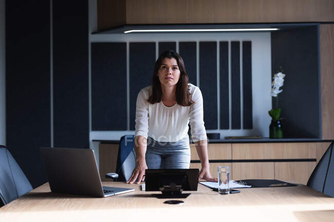 Retrato de una mujer de negocios caucásica de pie en la sala de reuniones de la oficina moderna. concepto de negocio y oficina - foto de stock