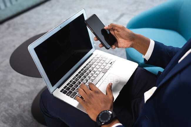 Der mittlere Teil der Geschäftsleute nutzt Laptop und Smartphone im modernen Büro. Geschäfts- und Bürokonzept — Stockfoto