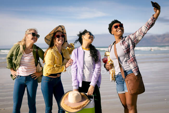 Fröhliche Gruppe unterschiedlicher Freundinnen, die Spaß haben, Selfies am Strand machen und lachen. Urlaub, Freiheit und Freizeit im Freien. — Stockfoto