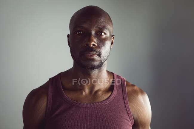 Retrato del hombre afroamericano en forma haciendo ejercicio en el gimnasio, mirando directamente a la cámara. estilo de vida activo saludable, entrenamiento cruzado para fitness. - foto de stock