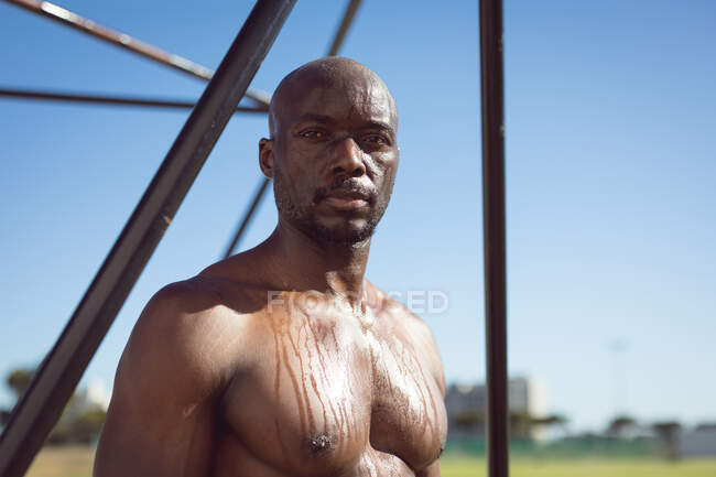 Portrait eines fitten, hemdslosen afrikanisch-amerikanischen Mannes, der im Freien trainiert und dabei eine Pause nach dem anderen einlegt. gesunder aktiver Lebensstil, Crosstraining für Fitness. — Stockfoto