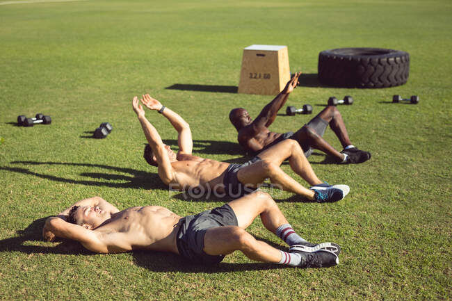 Grupo diverso de homens musculosos se exercitando ao ar livre. estilo de vida ativo saudável, treinamento cruzado para conceito de aptidão. — Fotografia de Stock