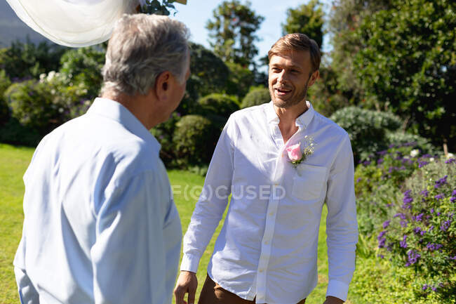 Caucasian groom getting married and talking with wedding officiant. summer wedding, marriage, love and celebration concept. — Stock Photo
