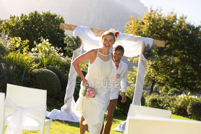 Happy caucasian bride and groom getting married and smiling. summer wedding, marriage, love and celebration concept. — Stock Photo