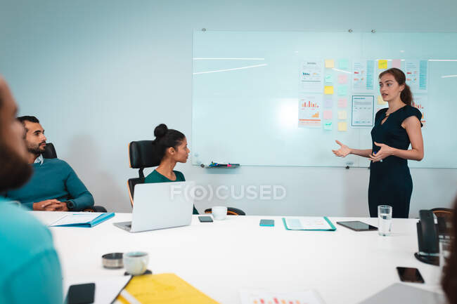 Eine Gruppe unterschiedlicher Geschäftsleute diskutiert gemeinsam bei einem Treffen und notiert sich Notizen. Arbeit in einem unabhängigen kreativen Unternehmen. — Stockfoto