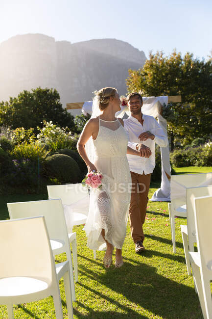 Noiva caucasiana feliz e noivo se casar e de mãos dadas. casamento de verão, casamento, amor e celebração conceito. — Fotografia de Stock
