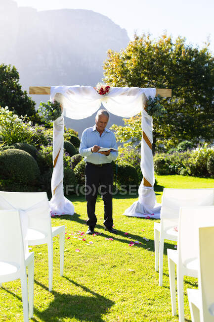 Oficial de casamento masculino caucasiano sênior preparando-se antes da cerimônia de casamento. casamento de verão, casamento, amor e celebração conceito. — Fotografia de Stock