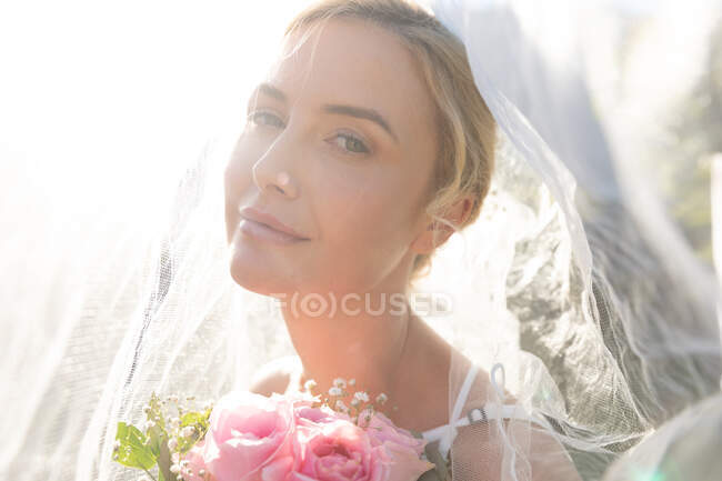 Portrait of happy caucasian bride getting married holding flowers. summer wedding, marriage, love and celebration concept. — Stock Photo