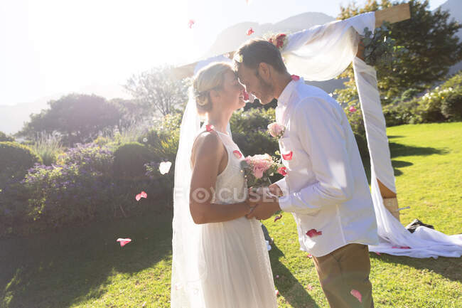 Heureuse mariée caucasienne et marié se marier toucher le front. mariage d'été, mariage, amour et concept de célébration. — Photo de stock