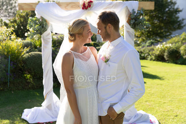 Happy caucasian bride and groom getting married and embracing. summer wedding, marriage, love and celebration concept. — Stock Photo