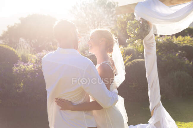 Felici sposi caucasici che si sposano e si abbracciano. matrimonio estivo, matrimonio, amore e concetto di celebrazione. — Foto stock