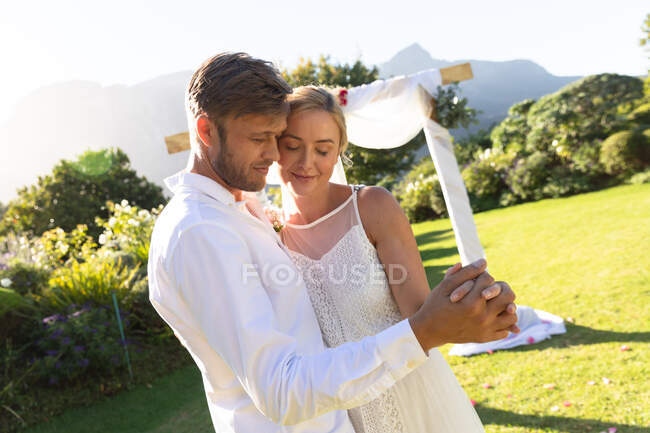 Happy caucasian bride and groom getting married and holding hands. summer wedding, marriage, love and celebration concept. — Stock Photo