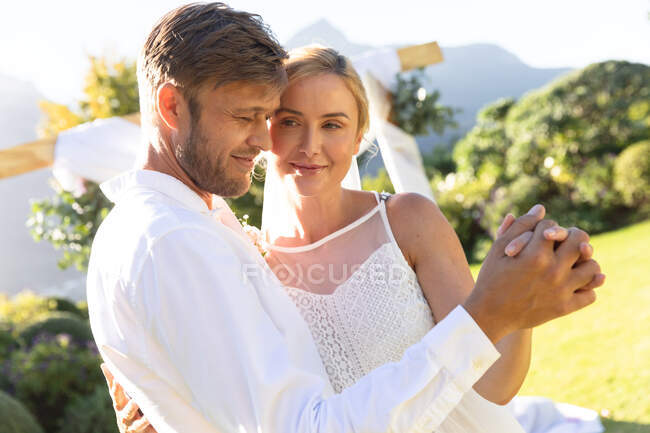 Felici sposi caucasici che si sposano e si tengono per mano. matrimonio estivo, matrimonio, amore e concetto di celebrazione. — Foto stock