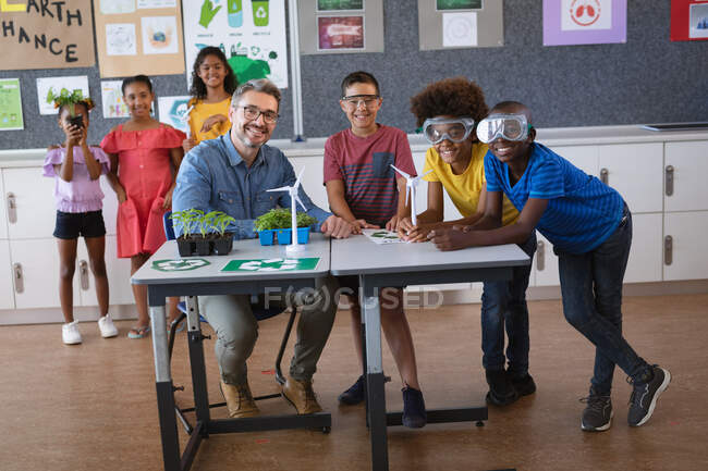 Portrait d'un enseignant caucasien et d'un groupe de garçons souriants pendant les cours d'environnement. concept scolaire et éducatif — Photo de stock