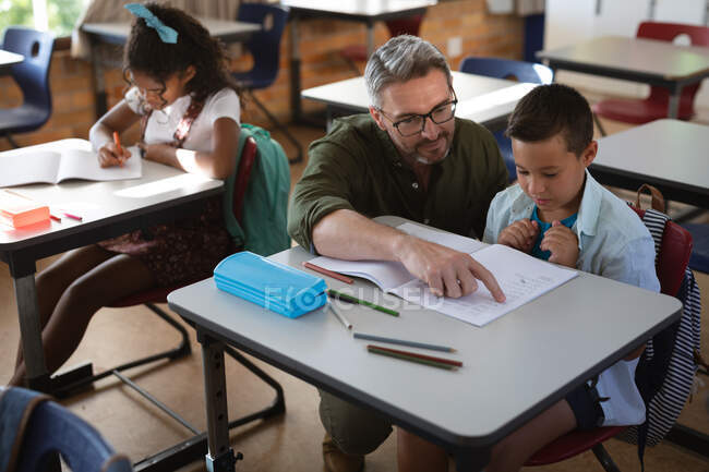 Homem branco professor de ensino caucasiano menino na classe na escola. conceito de escola e educação — Fotografia de Stock