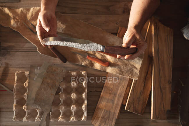 Руки козачого чоловіка-ножа в майстерні, тримаючи ніж ручної роботи. Незалежний дрібний майстер на роботі.. — стокове фото