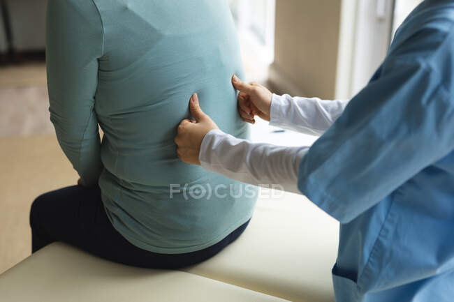 Fisioterapeuta do sexo feminino tratando paciente do sexo feminino em sua casa. tratamento de saúde e fisioterapia médica. — Fotografia de Stock
