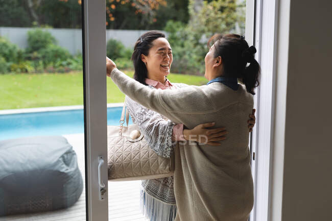Feliz mulher asiática sênior em casa com a filha adulta abraçando. estilo de vida sênior, passar tempo em casa com a família. — Fotografia de Stock