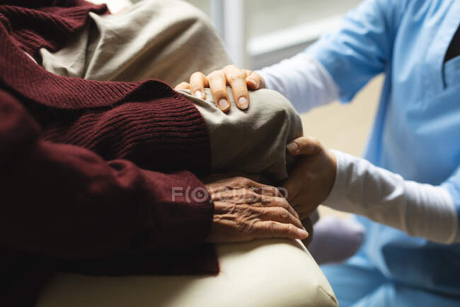 Female physiotherapist treating female patient at her home. healthcare and medical physiotherapy treatment. — Stock Photo