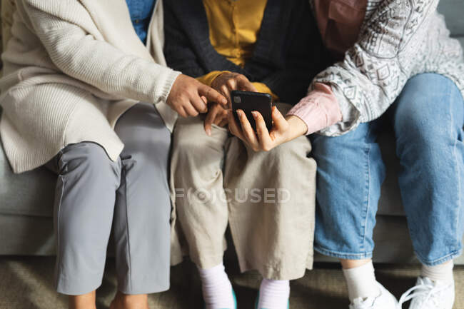 Азіатська жінка вдома з дочкою і онукою за допомогою смартфона. старший спосіб життя, проводячи час вдома з сім'єю . — стокове фото
