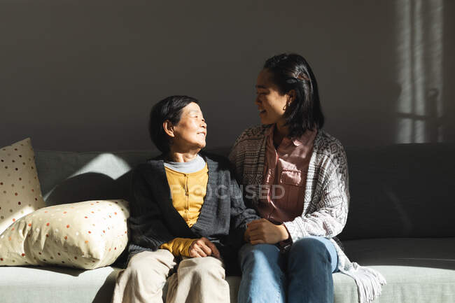 Щаслива старша азіатка вдома з онукою в обіймах. Старший спосіб життя, перебування вдома з родиною.. — стокове фото
