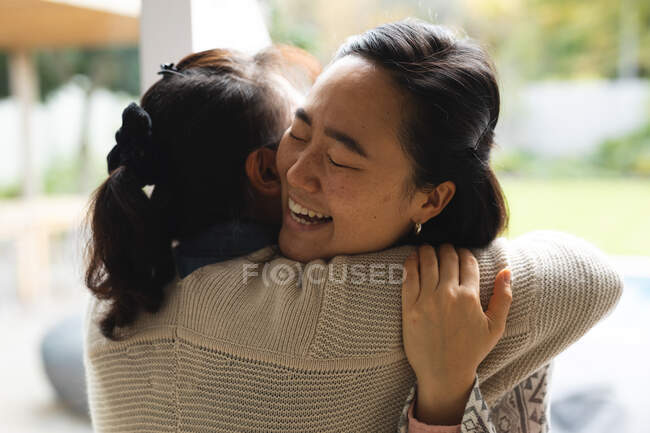 Happy senior asian woman at home with adult daughter embracing. senior lifestyle, spending time at home with family. — Stock Photo