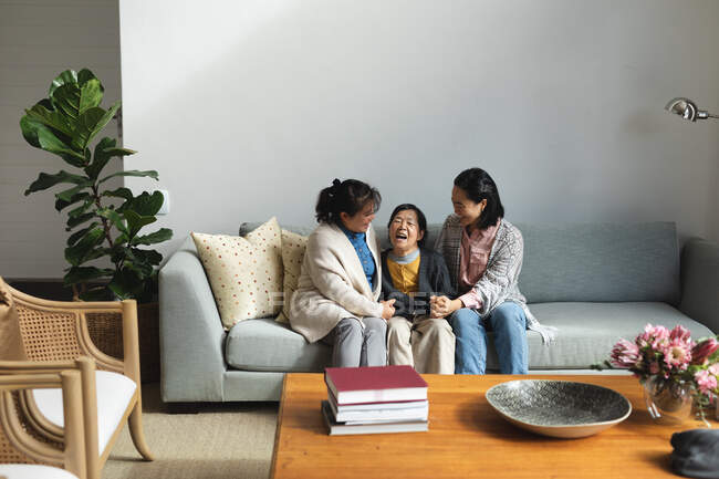 Happy senior asian woman at home with adult daughter and granddaughter embracing. senior lifestyle, spending time at home with family. — Stock Photo