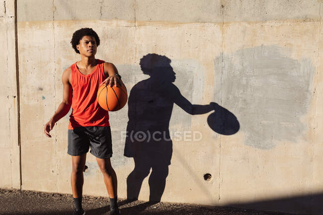 Fit african american man exercising in city playing basketball in the street. fitness and active urban outdoor lifestyle. — Stock Photo